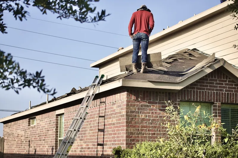 Professional roofer working on a residential roof in North Greenbush